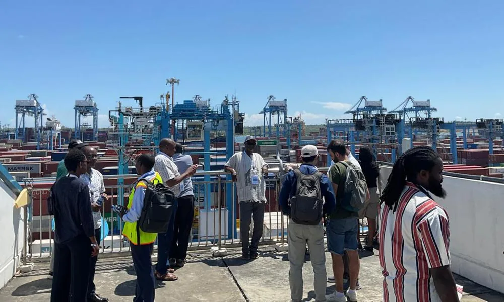 Nine people are standing on a terrace in the harbour area of Mombasa.