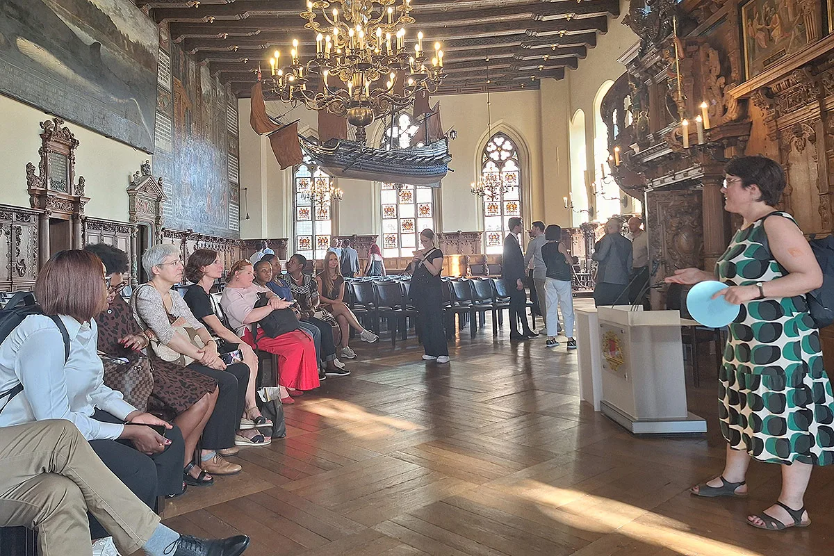 The participants are discussing in a historic hall