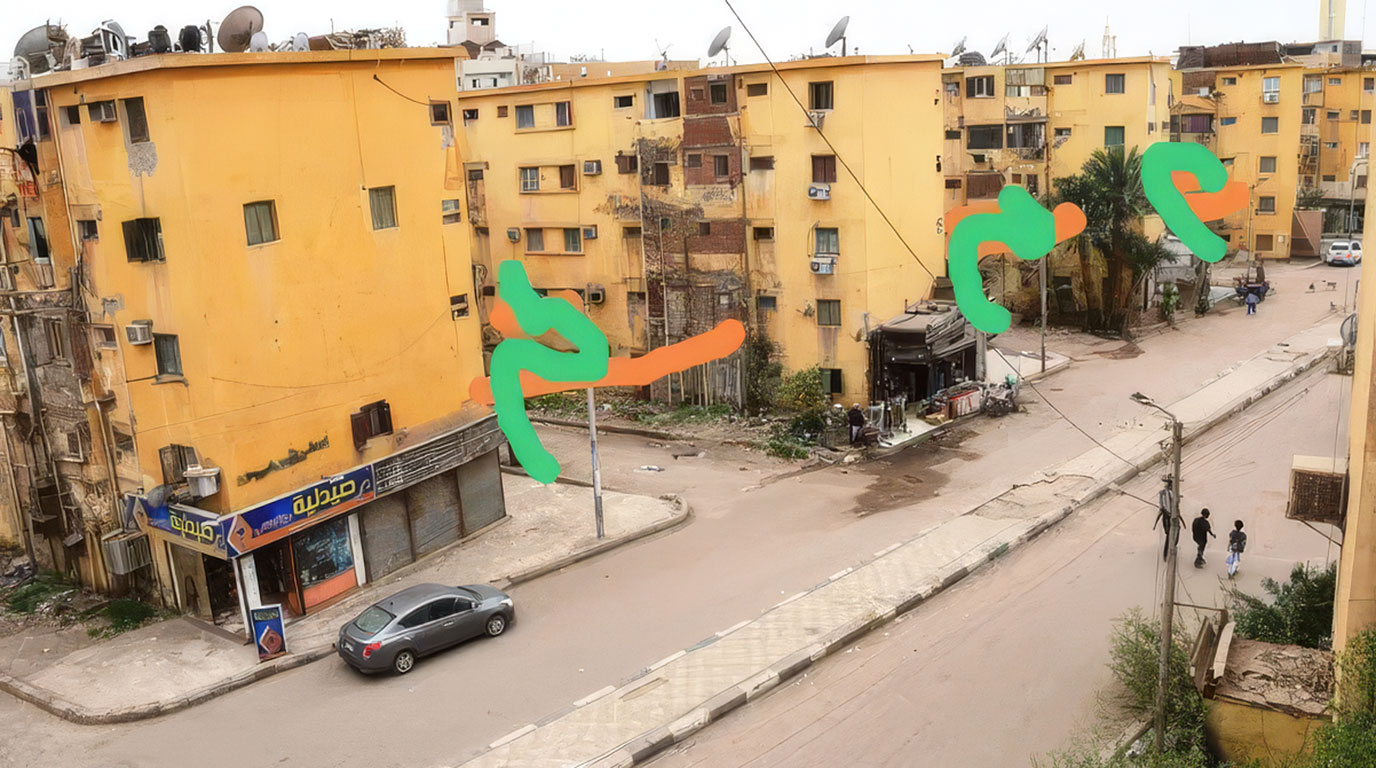 Straßenkreuzung vor gelben, teils verfallenen Mehrfamilienhäusern mit Satellitenschüsseln. Ein Auto parkt vor einer Apotheke, wenige Menschen gehen den Gehweg entlang. Grüne und orangefarbene Pinselstriche markieren Stellen für eine Umgestaltung.